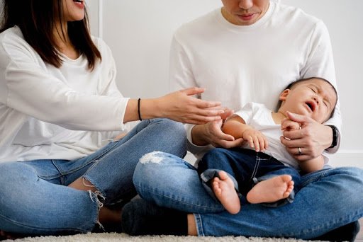 young couple holds baby
